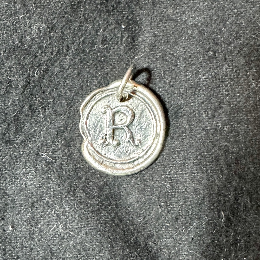Waxing poetic charm. Silver The letter R.